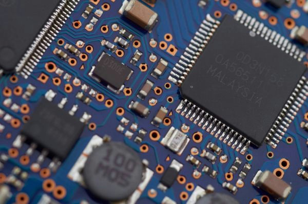 A close macro photograph of a circuit board, its copper tracks and soldered components filling the frame.